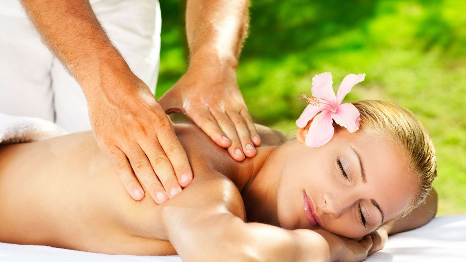 women with pink flower enjoying back massage