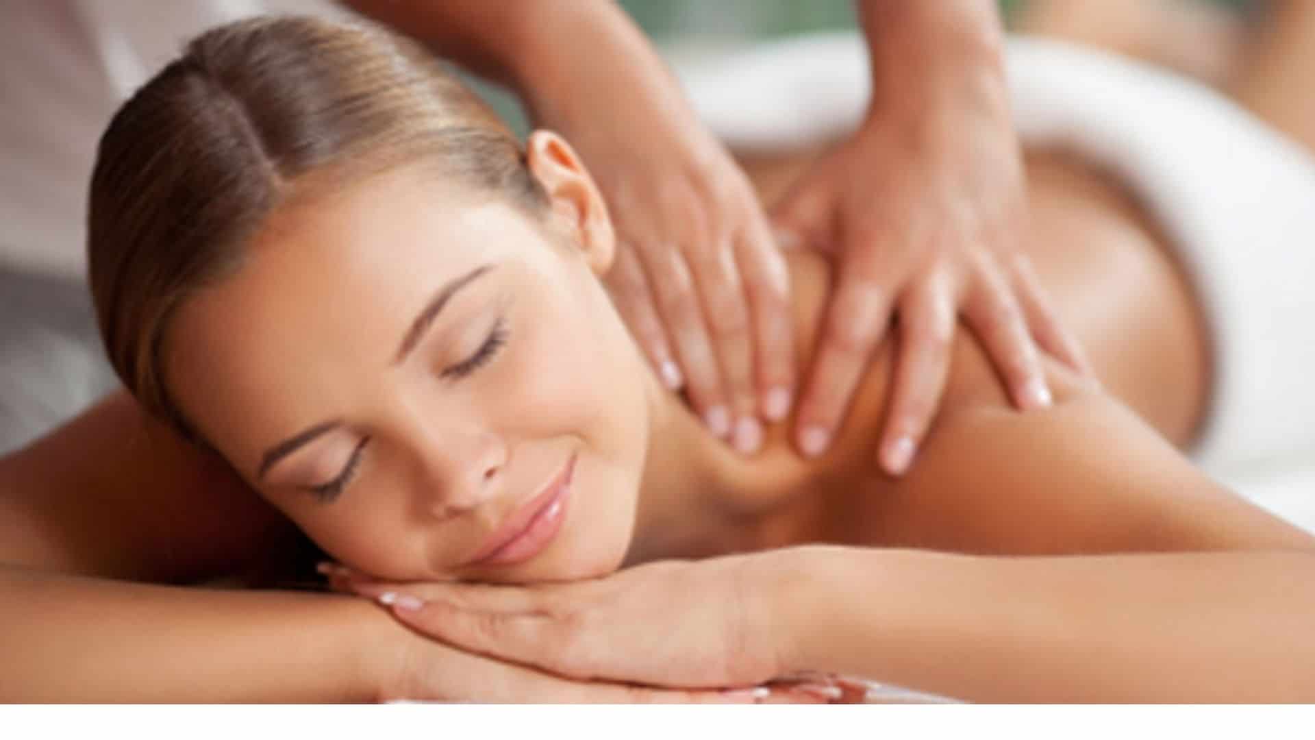 women lying on her stomach enjoying shoulder massage